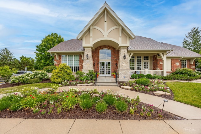 1728 Briarheath Dr, Aurora, IL 60505 - tudor home featuring brick siding, roof with shingles, a porch, and french doors