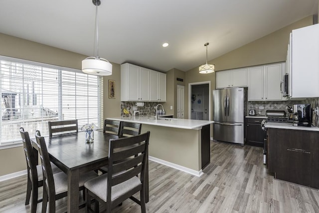 1444 Baroque Ave, Volo, IL 60073 - kitchen featuring stainless steel appliances, decorative backsplash, a peninsula, light countertops, and light wood-style flooring