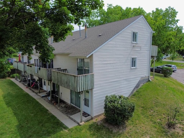 89 Maude Ave Unit A, Fox Lake, IL 60020 - rear view of property with a yard, roof with shingles, and a wooden deck