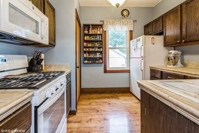 916 Pearl St, Aurora, IL 60505 - kitchen with white appliances, light countertops, dark brown cabinetry, and light wood-type flooring