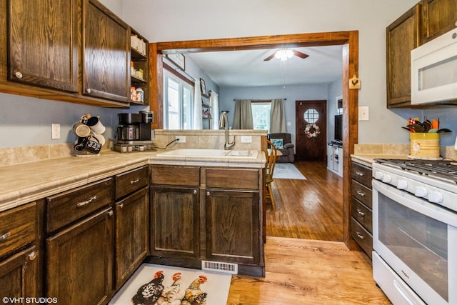 916 Pearl St, Aurora, IL 60505 - kitchen with white appliances, a peninsula, ceiling fan, light wood-style flooring, and dark brown cabinets