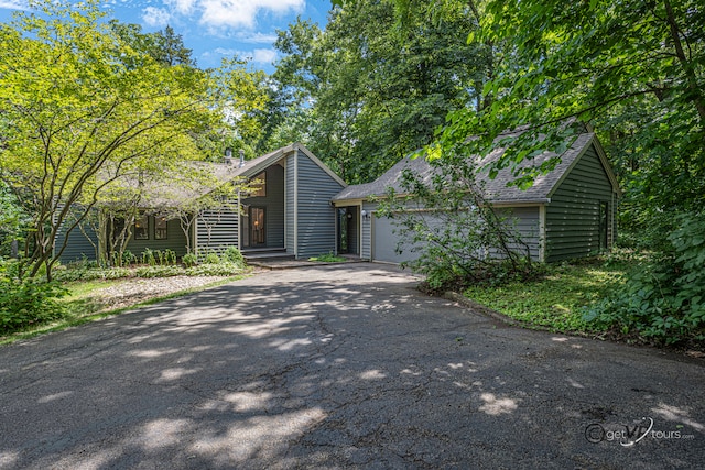 7 Vista Ridge Dr, Galena, IL 61036 - mid-century modern home with driveway, roof with shingles, and an attached garage