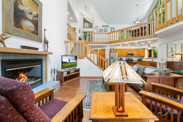 7 Vista Ridge Dr, Galena, IL 61036 - living room featuring stairs, light wood-style flooring, a fireplace, and high vaulted ceiling