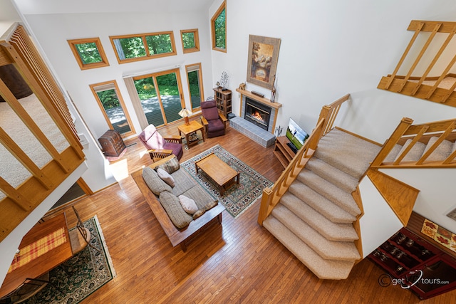 7 Vista Ridge Dr, Galena, IL 61036 - living room featuring stairway, hardwood / wood-style floors, a towering ceiling, and a glass covered fireplace