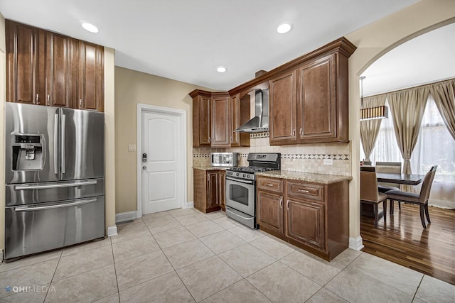 404 W Camp Mcdonald Rd, Prospect Heights, IL 60070 - kitchen with stainless steel appliances, wall chimney range hood, arched walkways, light stone counters, and backsplash
