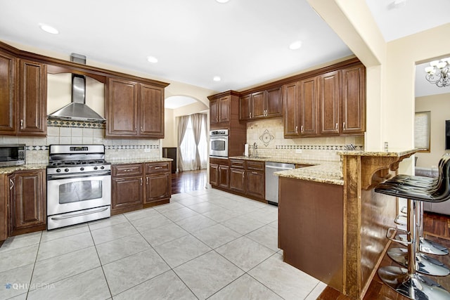 404 W Camp Mcdonald Rd, Prospect Heights, IL 60070 - kitchen featuring appliances with stainless steel finishes, wall chimney exhaust hood, a peninsula, tasteful backsplash, and recessed lighting