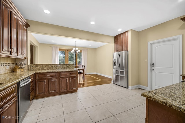 404 W Camp Mcdonald Rd, Prospect Heights, IL 60070 - kitchen featuring appliances with stainless steel finishes, a chandelier, light tile patterned floors, backsplash, and light stone countertops