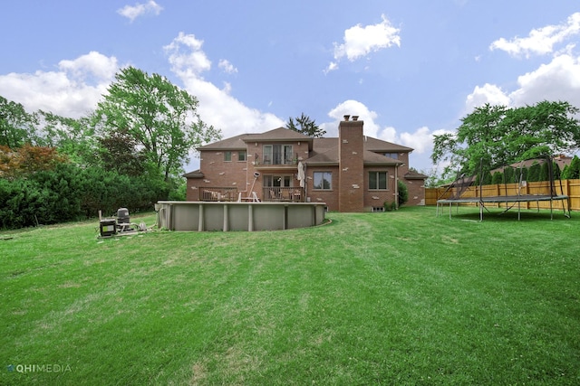 404 W Camp Mcdonald Rd, Prospect Heights, IL 60070 - back of property featuring a trampoline, a chimney, a yard, brick siding, and an outdoor pool