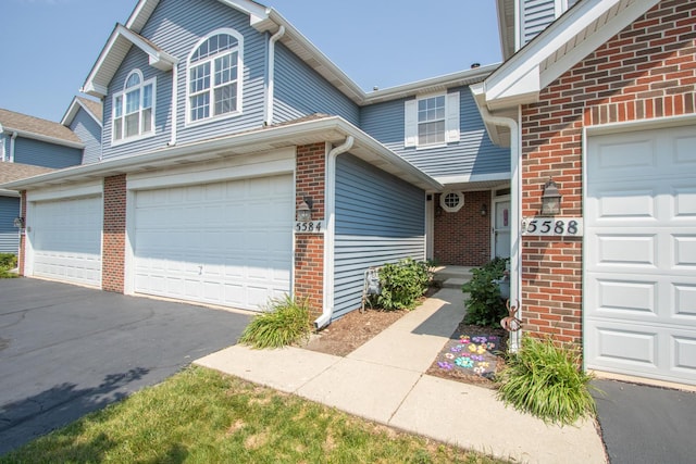 5584 Lavender Ct, Rolling Meadows, IL 60008 - view of front facade with brick siding, asphalt driveway, and an attached garage