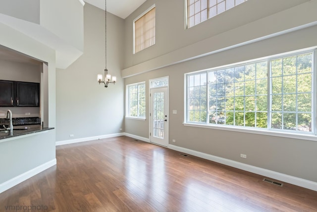 5584 Lavender Ct, Rolling Meadows, IL 60008 - unfurnished dining area with a chandelier, a high ceiling, and dark wood-style floors