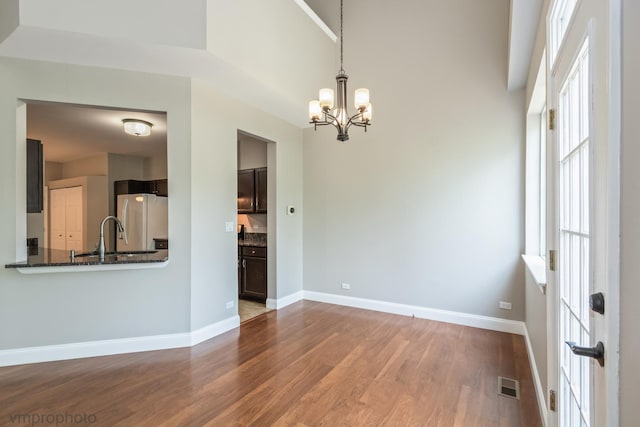 5584 Lavender Ct, Rolling Meadows, IL 60008 - spare room featuring a chandelier, wood finished floors, and a high ceiling