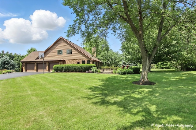 1815 Vineyard Ln, Spring Grove, IL 60081 - view of front of home with asphalt driveway, an attached garage, a front yard, and a chimney