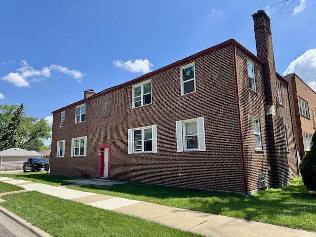 915 Bellwood Ave, Bellwood, IL 60104 - view of front facade with a chimney, brick siding, and a front yard
