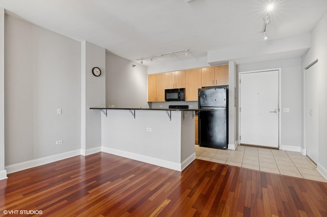 330 N Jefferson St Unit 2102, Chicago, IL 60661 - kitchen with black appliances, track lighting, light brown cabinets, and dark countertops