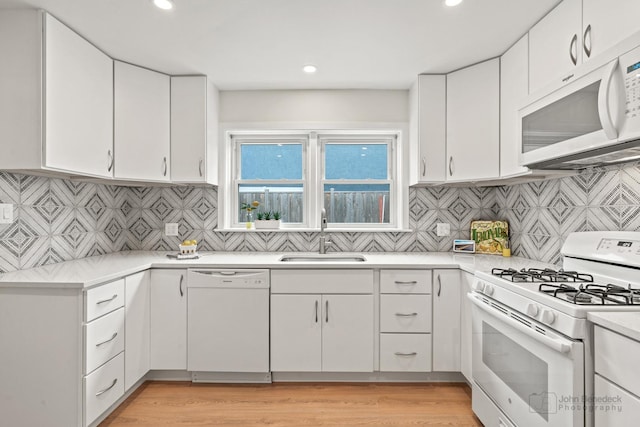 7025 W Berwyn Ave, Chicago, IL 60656 - kitchen with white appliances, light countertops, white cabinets, recessed lighting, and decorative backsplash