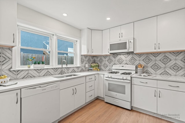 7025 W Berwyn Ave, Chicago, IL 60656 - kitchen featuring white appliances, white cabinetry, light countertops, decorative backsplash, and light wood-style floors