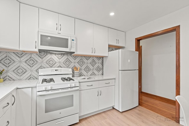 7025 W Berwyn Ave, Chicago, IL 60656 - kitchen with white appliances, light countertops, light wood-style floors, white cabinetry, and recessed lighting