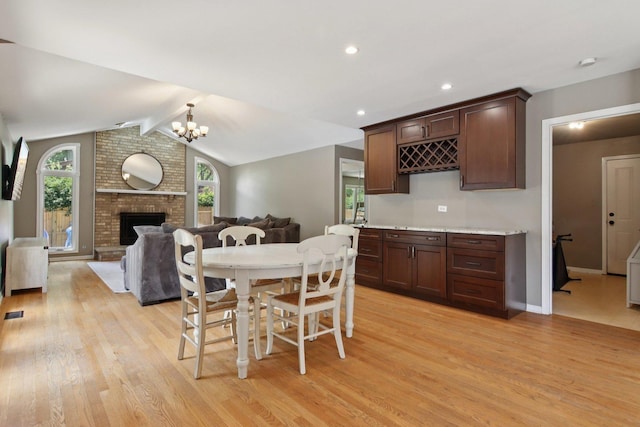 10215 S 87th Ct, Palos Hills, IL 60465 - dining space featuring light wood-type flooring, healthy amount of natural light, a fireplace, a chandelier, and recessed lighting