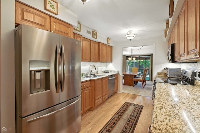 740 Saint Andrews Ln Unit 5, Crystal Lake, IL 60014 - kitchen featuring stainless steel appliances, brown cabinetry, light wood-type flooring, and light stone countertops