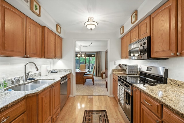 740 Saint Andrews Ln Unit 5, Crystal Lake, IL 60014 - kitchen featuring stainless steel appliances, light wood-style flooring, brown cabinetry, and light stone counters