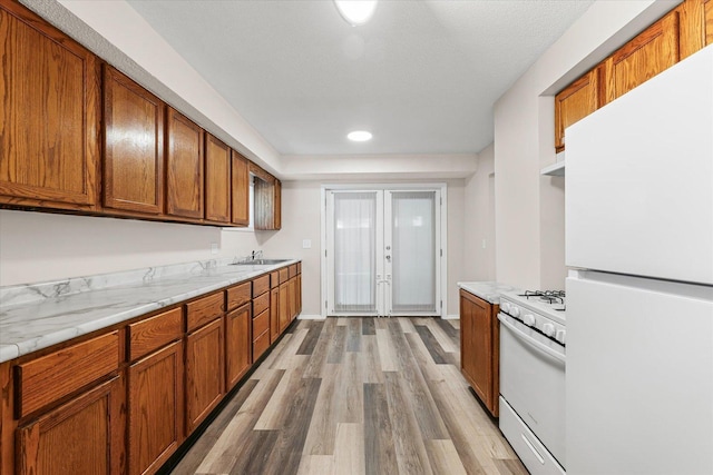 1010 N Neil St, Champaign, IL 61820 - kitchen featuring white appliances, light wood-style floors, light countertops, brown cabinetry, and recessed lighting