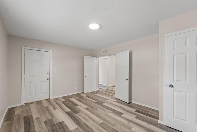 1010 N Neil St, Champaign, IL 61820 - unfurnished bedroom with light wood-style flooring