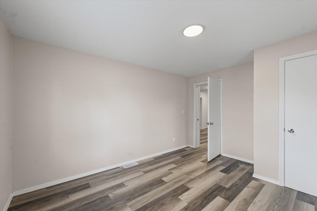 1010 N Neil St, Champaign, IL 61820 - unfurnished bedroom featuring wood finished floors and baseboards
