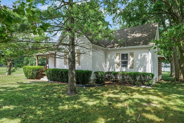 1010 N Neil St, Champaign, IL 61820 - view of side of home with a lawn and roof with shingles
