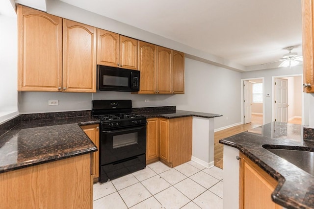 4008 W Nelson St Unit 8A, Chicago, IL 60641 - kitchen with black appliances, a peninsula, dark stone counters, a ceiling fan, and light tile patterned floors