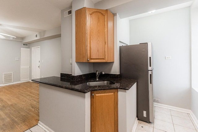 4008 W Nelson St Unit 8A, Chicago, IL 60641 - kitchen with freestanding refrigerator, dark stone counters, and light tile patterned flooring