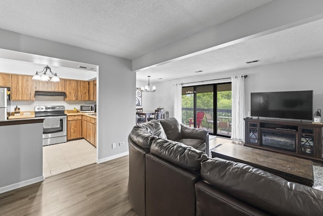 15141 Quail Hollow Dr Unit 106, Orland Park, IL 60462 - living room featuring a chandelier, a textured ceiling, and wood finished floors