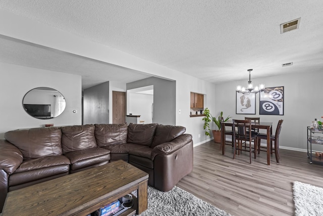 15141 Quail Hollow Dr Unit 106, Orland Park, IL 60462 - living area with a chandelier, light wood-style floors, and a textured ceiling