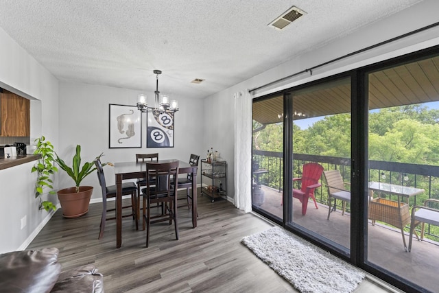 15141 Quail Hollow Dr Unit 106, Orland Park, IL 60462 - dining space featuring plenty of natural light, wood finished floors, a textured ceiling, and a chandelier