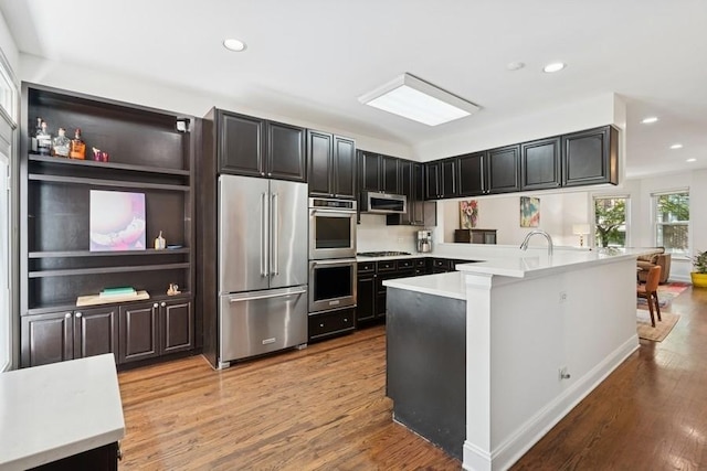 250 W Scott St Unit C, Chicago, IL 60610 - kitchen with stainless steel appliances, light wood-style flooring, light countertops, recessed lighting, and dark cabinets