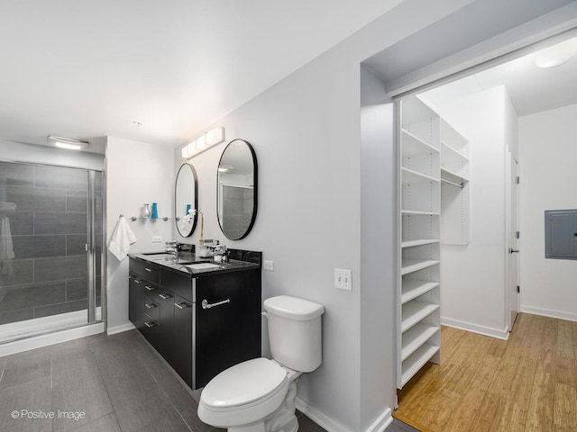 659 W Randolph St Unit 421, Chicago, IL 60661 - bathroom with electric panel, double vanity, a shower stall, wood finished floors, and a walk in closet
