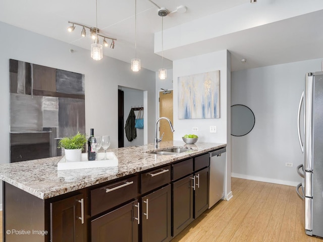 659 W Randolph St Unit 421, Chicago, IL 60661 - kitchen featuring stainless steel appliances, light wood-type flooring, dark brown cabinets, light stone counters, and pendant lighting