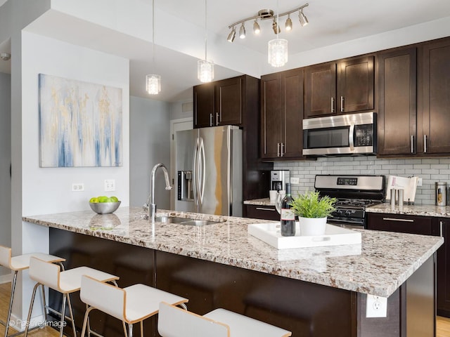 659 W Randolph St Unit 421, Chicago, IL 60661 - kitchen featuring appliances with stainless steel finishes, backsplash, dark brown cabinets, and a breakfast bar
