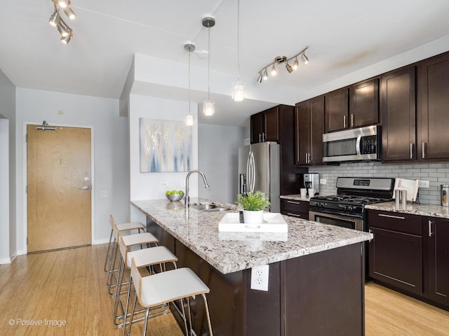 659 W Randolph St Unit 421, Chicago, IL 60661 - kitchen featuring appliances with stainless steel finishes, light wood-type flooring, a kitchen bar, and decorative backsplash