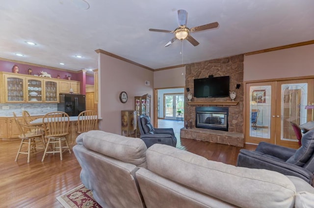 12571 W 3000 N Rd, Bonfield, IL 60913 - living area featuring crown molding, light wood finished floors, ceiling fan, french doors, and a stone fireplace