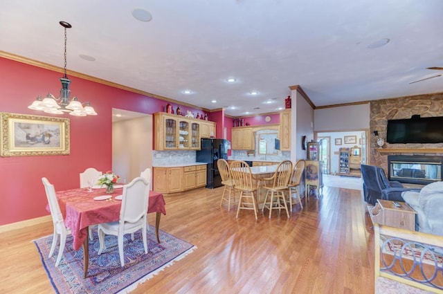 12571 W 3000 N Rd, Bonfield, IL 60913 - dining room featuring ornamental molding, light wood-type flooring, a stone fireplace, and a chandelier