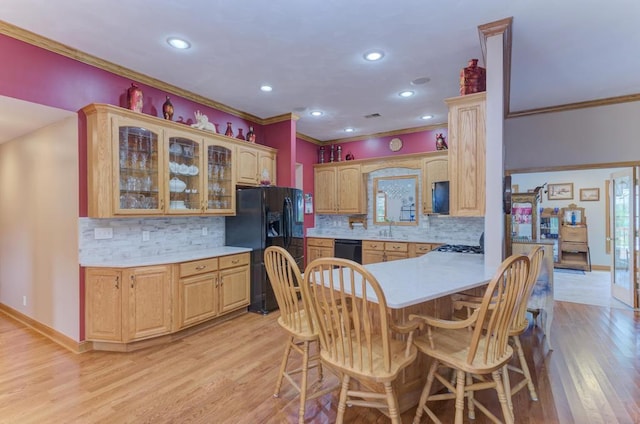 12571 W 3000 N Rd, Bonfield, IL 60913 - kitchen featuring black appliances, crown molding, light countertops, a kitchen breakfast bar, and glass insert cabinets