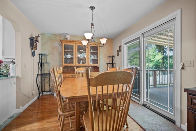 204 Collins Dr, Normal, IL 61761 - dining room with light wood finished floors, a chandelier, and arched walkways
