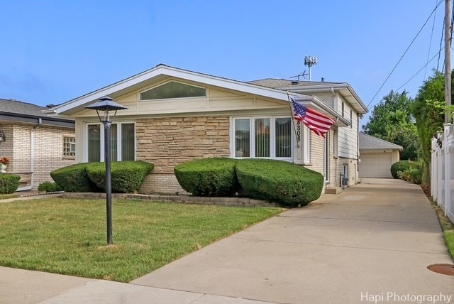 8308 W Leland Ave, Norridge, IL 60706 - view of front facade featuring stone siding, a front yard, and a detached garage