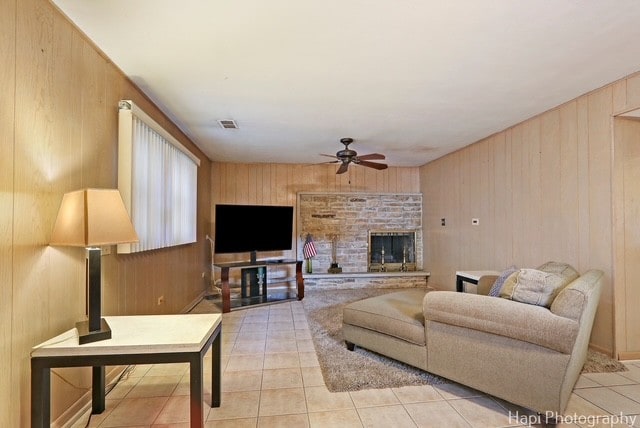 8308 W Leland Ave, Norridge, IL 60706 - living area with a ceiling fan, wood walls, light tile patterned flooring, and a stone fireplace