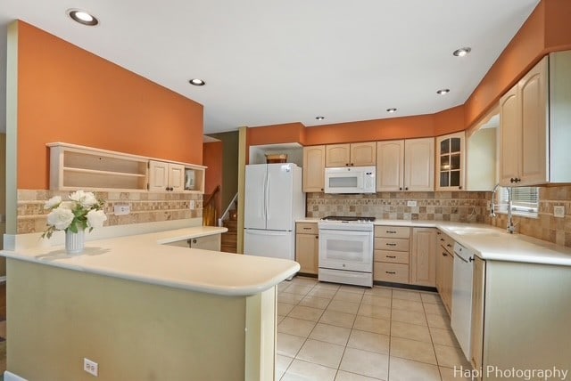 8308 W Leland Ave, Norridge, IL 60706 - kitchen featuring white appliances, a peninsula, backsplash, glass insert cabinets, and light countertops