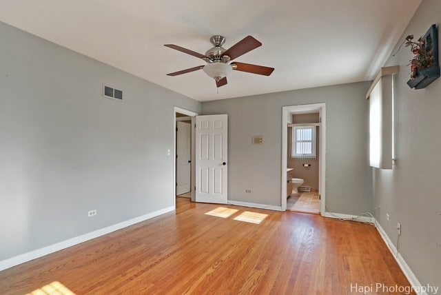8308 W Leland Ave, Norridge, IL 60706 - unfurnished bedroom with light wood-style flooring, ensuite bath, and a ceiling fan