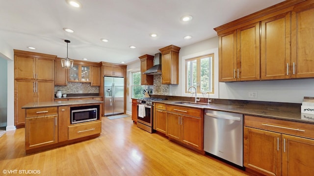 27W558 Ridgeview St, West Chicago, IL 60185 - kitchen with appliances with stainless steel finishes, wall chimney range hood, brown cabinetry, light wood-style flooring, and decorative backsplash