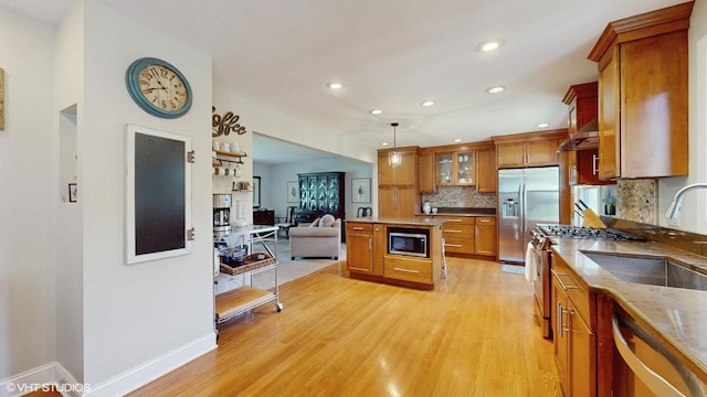27W558 Ridgeview St, West Chicago, IL 60185 - kitchen with built in appliances, brown cabinetry, light wood finished floors, backsplash, and a center island