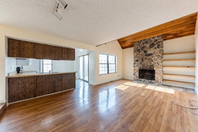 758 Sizer Rd, Gurnee, IL 60031 - unfurnished living room featuring wood finished floors, a textured ceiling, lofted ceiling, and a fireplace