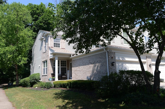1420 Yellowstone Dr, Streamwood, IL 60107 - view of front of property with brick siding, a garage, and a front lawn